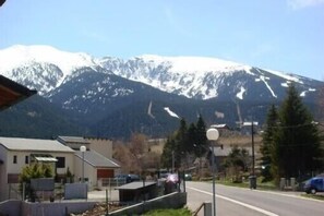A mountain view with a road and buildings in the foreground. - APARTMENT FOR 4 PEOPLE LOWER CHALET GARDEN FENCE BARBECUE PLACE QUIET (Saint-Pierre-Dels-Forcats)