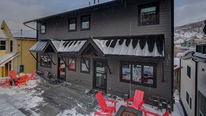 A two-story building with a covered porch and red Adirondack chairs. - Woodside Ave - Close to Sundance Locations - Private Hot Tub (Park City)