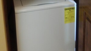 A stacked washer and dryer unit with a yellow energy efficiency label. - Vacation Rental Available (Scottsdale)