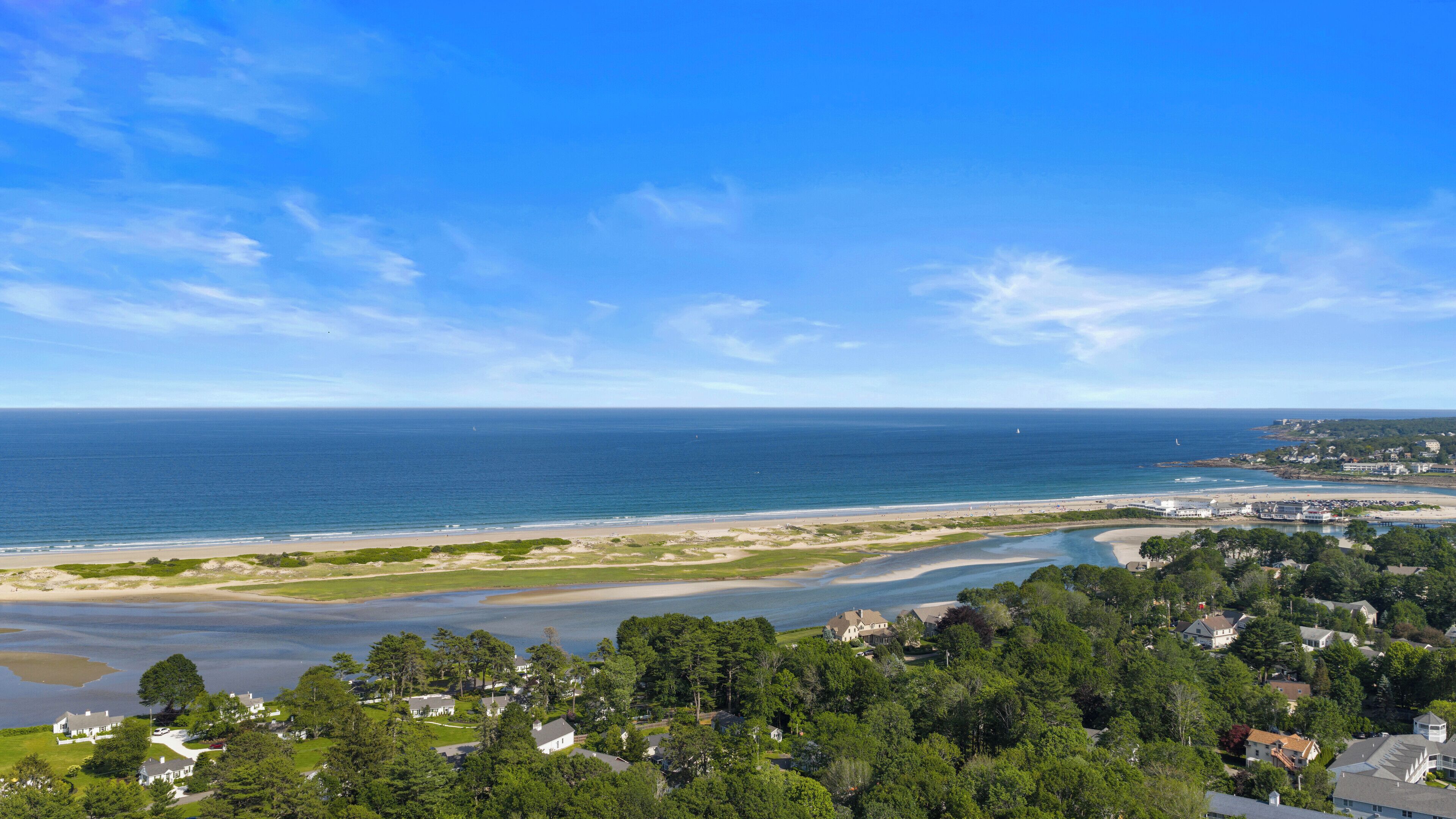 Un quartier résidentiel situé sur la côte, avec des maisons, une plage et une vue sur l’océan.