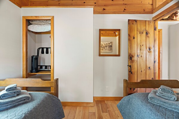 A room with two beds, a wooden ceiling, a small closet with a heater, and a framed picture on the wall. - Beach Cottage in the trees and near the sea.
Bigger than it looks!! (Ogunquit)