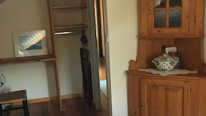 A bedroom with a wooden ladder, a wooden cabinet with glass doors, and a bed. - Small house in the middle of the forest.  (Saint-Remy)
