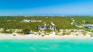 A coastal property with multiple houses, a beach, and a clear view of the ocean. - Brise De Mer 6 BR Villa (Long Bay)