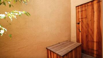 A wooden bench and a door in a room with a textured wall.