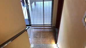 Eine Treppe mit Teppichstufen und weißen Geländern, die zu einer Tür mit Oberlicht führt.