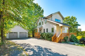 A two-story house with a front porch, a garage, and a driveway.