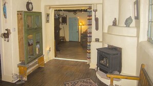 Una stanza accogliente con pavimento in legno, un armadietto verde, un fornello nero e una porta blu sullo sfondo.
