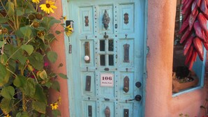 Una porta color turchese con un'insegna che riporta "106 Dona Luz".