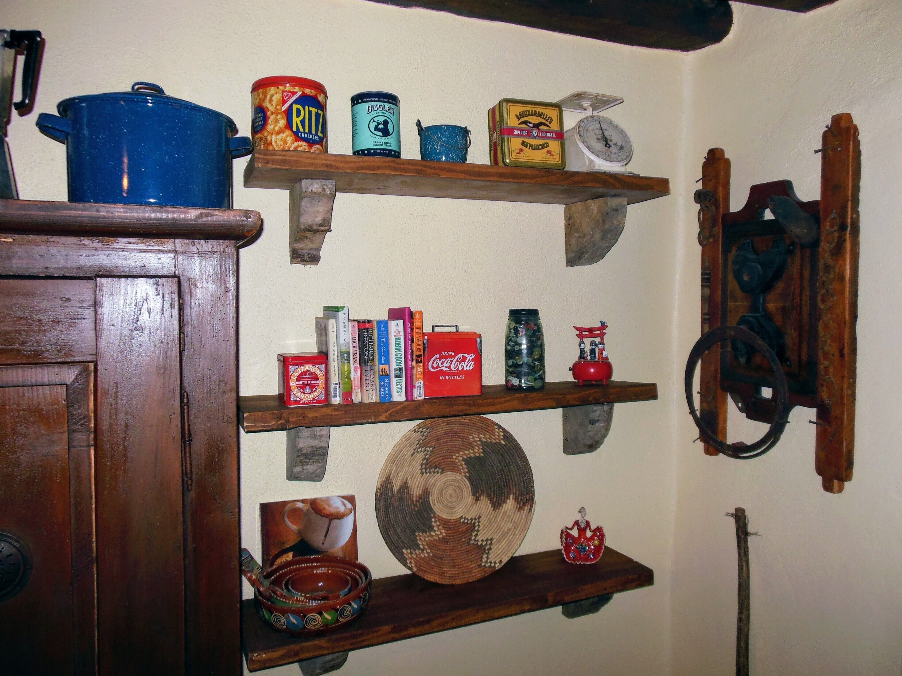 A kitchen shelf with various food items, a blue pot, and a vintage scale.