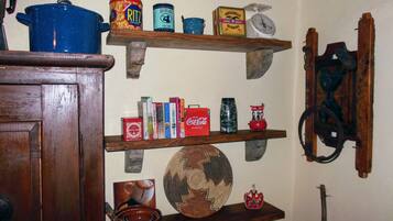 A kitchen shelf with various food items, a blue pot, and a vintage scale.
