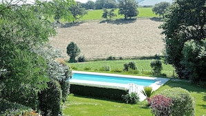 A landscaped garden with a swimming pool, surrounded by neatly trimmed hedges and trees. - Vacation in the heart of the Basque Country, swimming pool, quiet mountain views (Ossès)