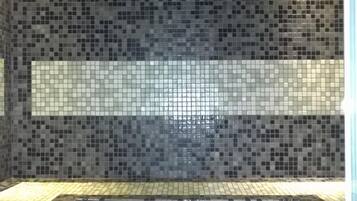 Bathroom features a tiled floor and walls with a decorative pattern.