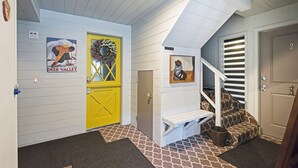 A hallway with a yellow door, a staircase with animal print steps, and a wall-mounted picture. - Acorn Chalet #2 - Walk to PC ski base! - 1BD (Park City)