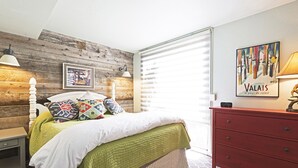 A bedroom with a wooden headboard, a bed with a green quilt, a red dresser, and a window with blinds. - Acorn Chalet #2 - Walk to PC ski base! - 1BD (Park City)