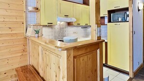 A compact kitchen with wooden cabinets, a microwave, and a sink.