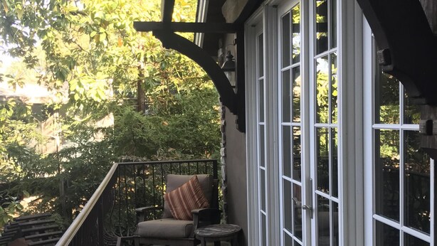 A covered porch with a stone floor, a bench, a chair, and a small table. - Creekside Casita walking distance to downtown San Carlos (San Carlos)