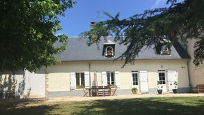 Une maison à deux étages avec un jardin à l’avant.