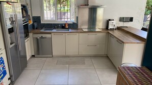 Een moderne keuken met roestvrijstalen apparatuur, een vaatwasser en een koffiezetapparaat.