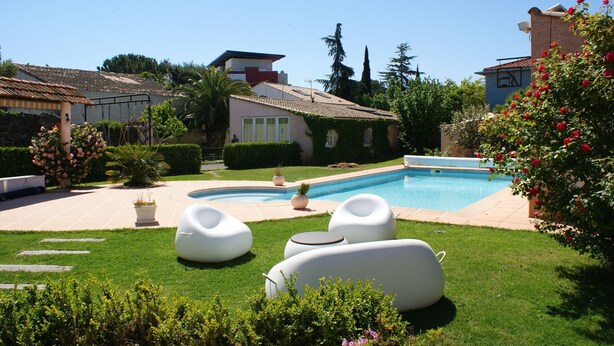 A swimming pool with lounge chairs, a well-maintained lawn, and a house with a tiled roof. - GITE FOR 4 PERS WITH POOL (Agde)