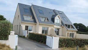 A modern two-story house with a sloped roof, large windows, and a gated entrance. - PIRIAC SUR MER Large T2 full SEA FACE Terrace WIFI broadband (Piriac-Sur-Mer)