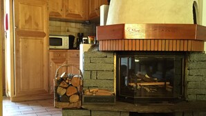 Una chimenea de piedra con chimenea, un armario de madera y un suelo de baldosas.