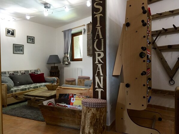 A cozy living room with a sofa, a coffee table, and a wooden sign reading "STAURANT".