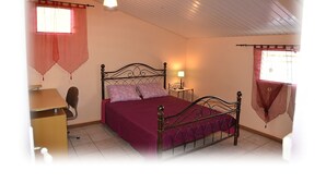 A bedroom with a bed, a desk, and a chair. - T2 Apartment Countryside View (st joseph)