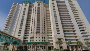 A multi-story hotel with a central courtyard, balconies, and a modern architectural design.
