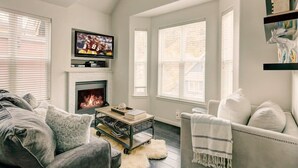 A living room with a fireplace, a television, and a sofa.