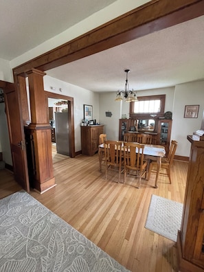 A spacious kitchen with wooden cabinets, a dining table, and chairs.