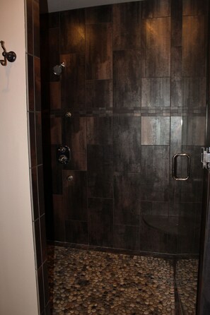 A shower with dark wooden tiles and a tiled floor. - Penthouse in the heart of Downtown Fargo with private rooftop patio (Fargo)