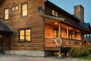 A log cabin with a porch, multiple windows, and a chimney. - 6-BR Teton View Ranch with Hot Tub (Driggs)