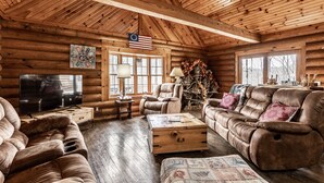 A log cabin interior with a large wooden ceiling, a television, leather sofas, and a rustic decor. - CIDER CABIN - Brown County's Finest Log Cabin (Nashville)