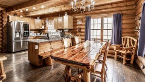 A log cabin interior with a kitchen, dining area, and a chandelier. - CIDER CABIN - Brown County's Finest Log Cabin (Nashville)