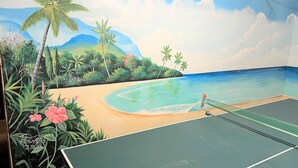 Un court de tennis orné d’une fresque représentant une scène de plage.