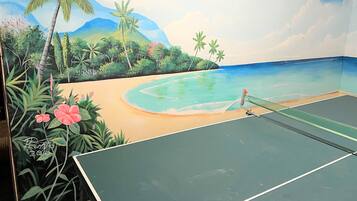 A tennis court with a mural of a beach scene.