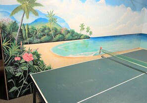 A tennis court with a mural of a beach scene.