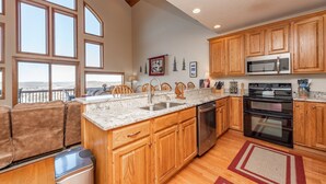 A kitchen with wooden cabinets, a stainless steel sink, a dishwasher, a microwave, and an oven. - Dog Friendly Deep Creek Escape w/ Mountain Views (McHenry)