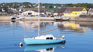 A calm harbor with a small sailboat anchored near the shore. - In a "fisherman's house" spirit, between Finistère and the pink granite coast (Plouezoc'h)