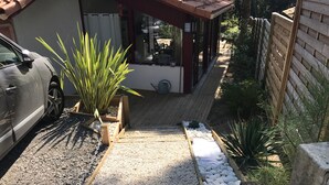 A pathway leading to a building with a covered porch, surrounded by gravel and small plants. - House in Moliets et Maâ for 5 people (Moliets-Et-Maa)