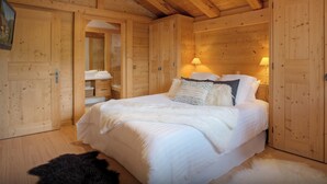 A wooden room with a bed, a nightstand, and a lamp. - Chalet Timan - ski-in ski-out break for 8, spa & views - OVO Network (La Clusaz)