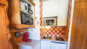 A compact kitchen with a microwave, coffee maker, and a Bosch dishwasher.