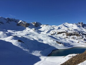 Un paisaje montañoso cubierto de nieve con cielo azul despejado.