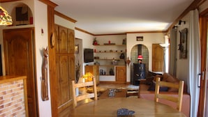 Un accogliente soggiorno con un tavolo rotondo in legno, un camino e un televisore.