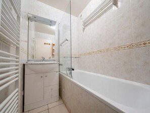 Un bagno con vasca, cabina doccia in vetro e mobile lavabo con specchio.