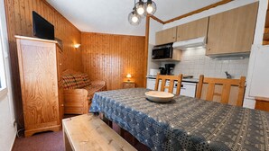 Una cucina compatta con mobili in legno, un forno a microonde e un fornello.