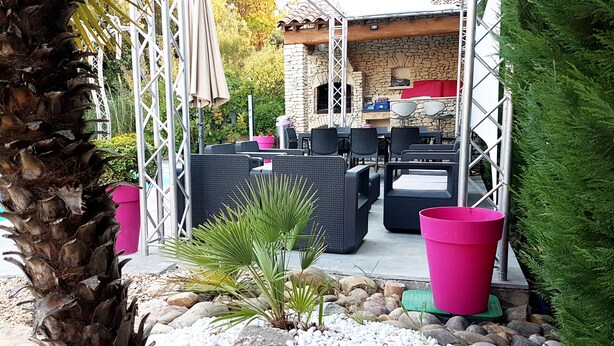 An outdoor patio area with wicker furniture, a stone wall, and a pool. - Magnificent charming villa with private pool in Sorgues 10 minutes from Avignon  (Sorgues)