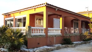 A two-story house with a red facade, white window frames, and a stone foundation. - Magnificent charming villa with private pool in Sorgues 10 minutes from Avignon  (Sorgues)