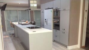 A modern kitchen with a central island, stainless steel appliances, and a light wood floor. - Magnificent charming villa with private pool in Sorgues 10 minutes from Avignon  (Sorgues)