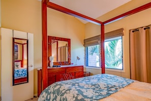 Una camera da letto con un letto, una cassettiera in legno, uno specchio, una finestra con tende e una porta.